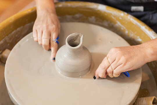 Artisan Perfecting Clay Pot Shape with Gentle Touch