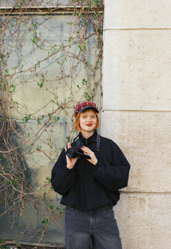Young woman with camcorder posing in a casual outfit