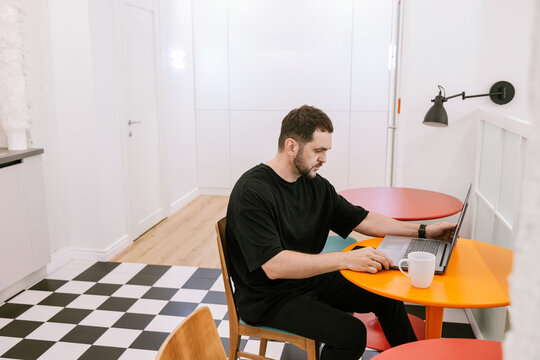 A man concentrates at work on a laptop in a modern office