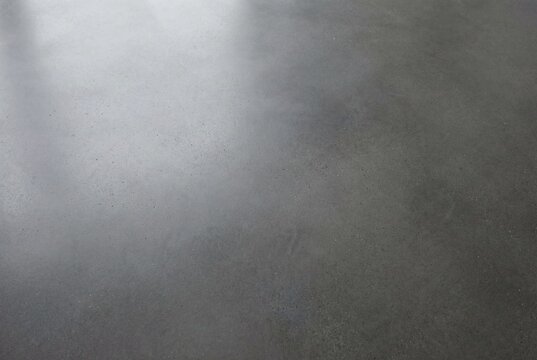 Dark grey polished concrete surface texture with a smooth finish and consistent pattern