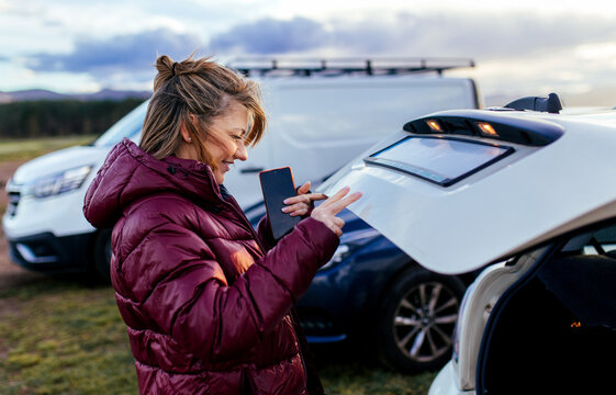 Woman Opening Car Trunk Outdoors