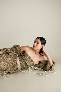Nonbinary person wearing elegant long strapless dress