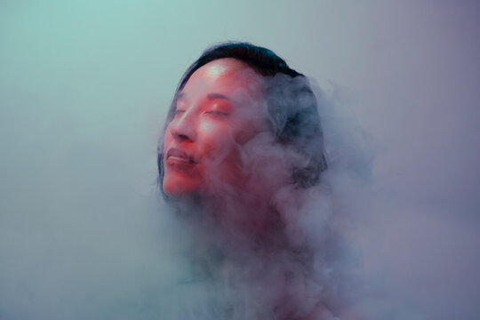 Dreamy woman portrait covered by smoke