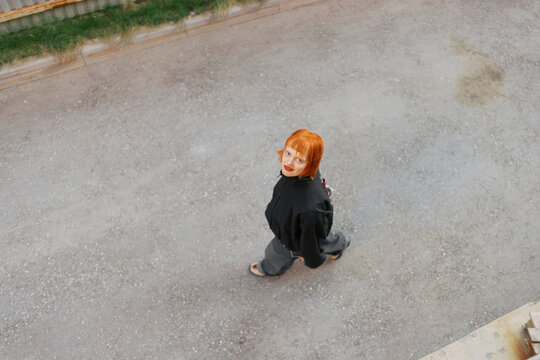 Redheaded Individual Walking Outdoors on a Clear Day Viewed From Above