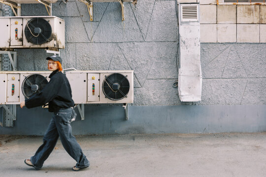 Urban Scene with Person Walking by a Wall with Air Conditioners