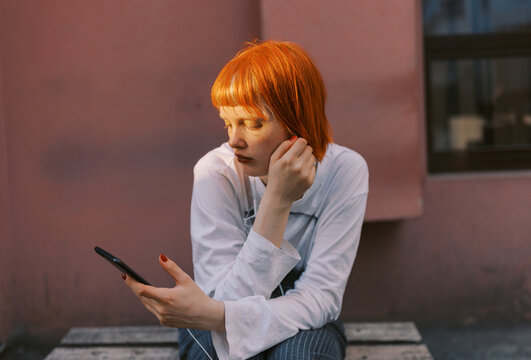 Portrait of a Person Taking a Selfie Outdoors Against a Pink Wall