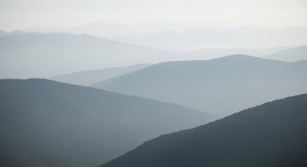 Layered mountain ranges fade into a soft, hazy blue sky.