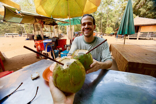 Tourist Drinking Fresh Coconut at a Roadside Stall