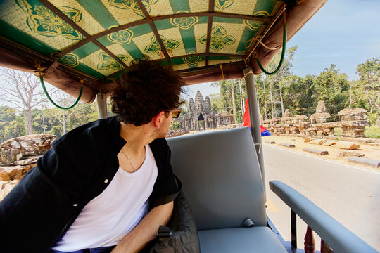 Tourist Riding a Tuk-Tuk Toward Temple Ruins in Siem Reap