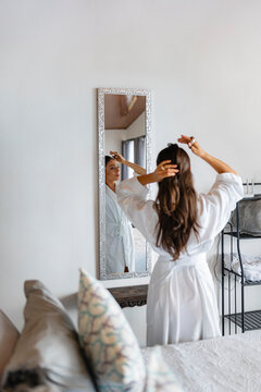 Styling hair in front of mirror
