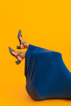 Anonymous woman with  blue heels showing legs wrapped in blue dress