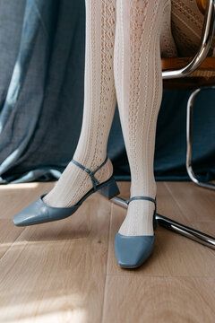 Socks and blue heels of woman sitting on chair