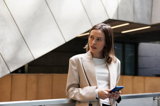 Businesswoman Holding Phone Looking Away