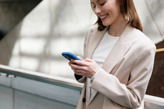 Smiling Businesswoman Texting on Phone