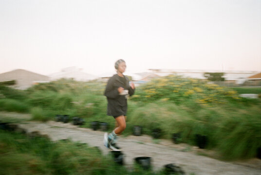 Wide angle portrait of woman jogging at sunset
