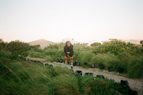 Wide angle portrait of woman resting after jogging at sunset