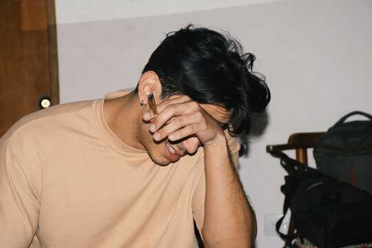 man rubbing eyes in pain holding joint 