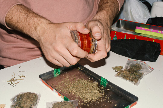 person scraping marijuana herb tray 