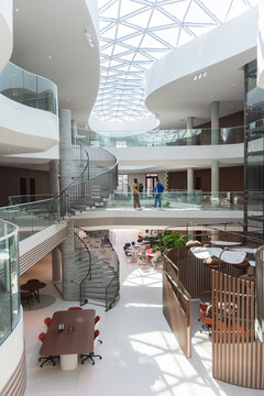 Bright modern coworking atrium with skylight and spiral staircase