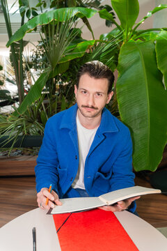 Man Taking Notes In Modern Office