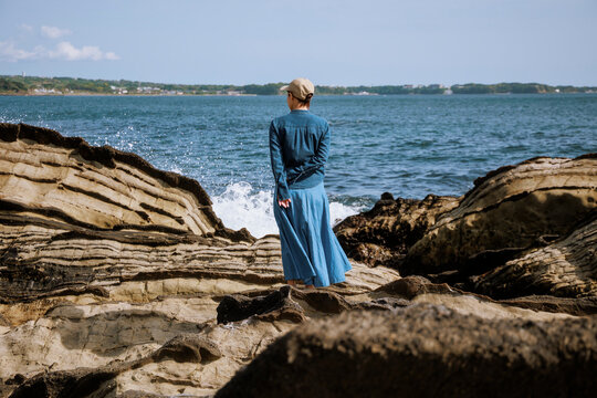 A woman resonating with nature amidst the sound of waves.