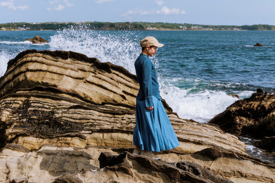 A woman resonating with nature amidst the sound of waves.