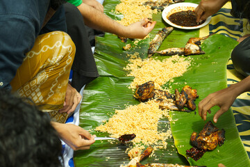 Traditional Communal Feast on Banana Leaves, Authentic Indonesian Family Gathering with Grilled Chicken and Shared Rice, Cultural Culinary Experience