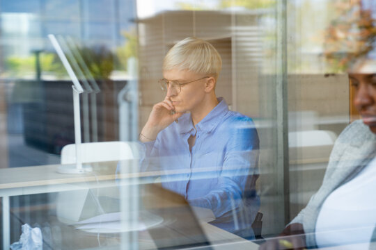Focused Businesswoman Seen Working Through Window