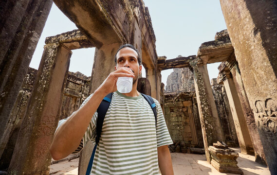 Man Drinking Water Inside Ancient Temple Complex