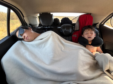 Mother and Son Sleeping in the Backseat During Road Trip UGC