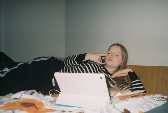 Teen Girl on Bed Making Peace Sign - film analog