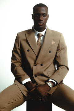 portrait of a black model looking at camera wearing a suit