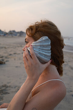 Redheaded Girl Listening to Metal Seashell