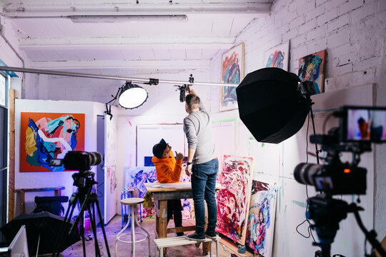 Cameraman adjusting overhead camera in studio

