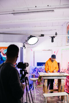 Artist drawing at table under overhead camera

