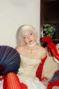 Young woman with wig and fan, fashion portrait