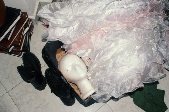 Styrofoam head on floor with flowing skirt, shoes, brush, and book