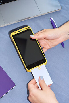 Hands holding payment terminal inserting card