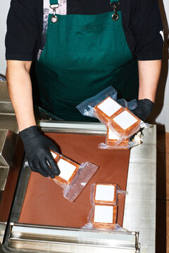 A worker vacuum seals frozen food products