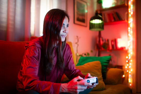 Focused gamer playing at colorful living room