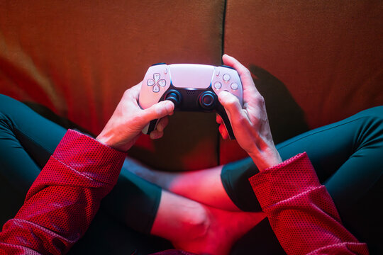 Hands playing video games with console controller
