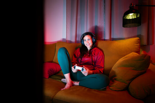 Woman having fun playing video games on sofa