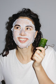 Young woman with moisturizing sheet mask on her face