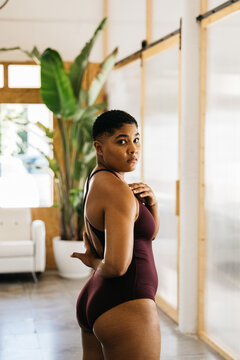 Woman posing with hand behind back in studio
