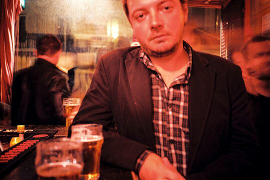 Portrait of a man standing at a Bar in Low-Lit Pub 