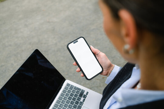 A woman uses a mobile phone with white screen