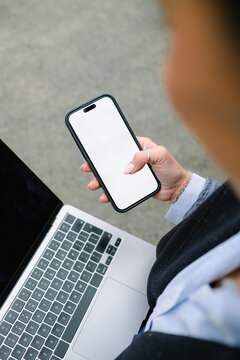 A woman uses a mobile phone with white screen