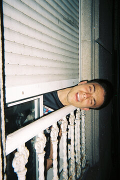 Young Man caught in funny moment sticking head out window at night
