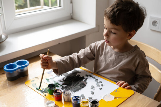 The Child Draws With Paints