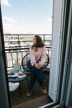 Woman sitting on hotel balcony